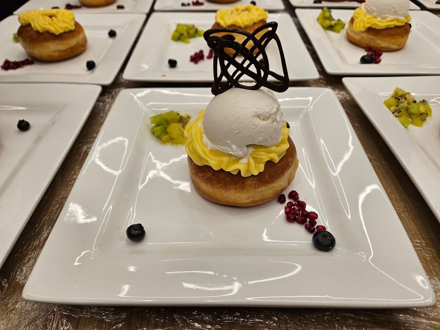 Plated dessert with ice cream and a chocolate garnish