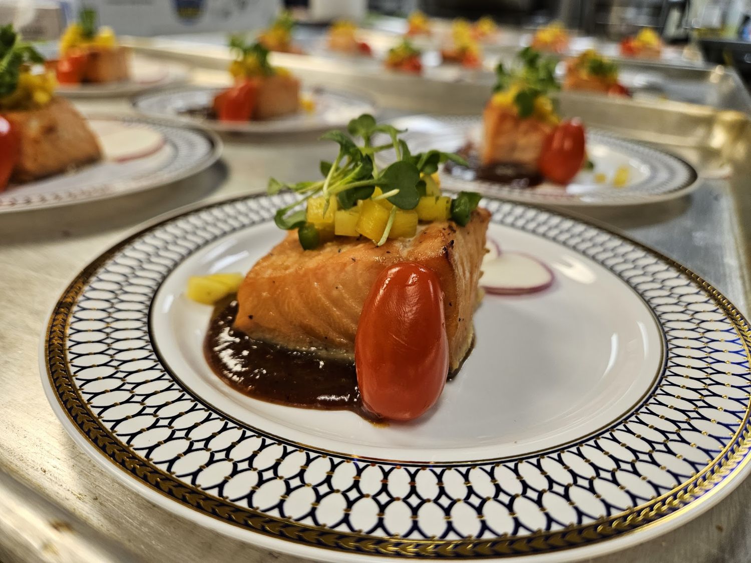 Plated salmon with roasted tomato on a patterned plate
